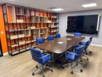 A large room for business meetings with a screen